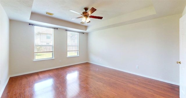 3606 Kilgore Ct, Manvel, TX 77578 - empty room featuring a tray ceiling, wood finished floors, ceiling fan, and baseboards