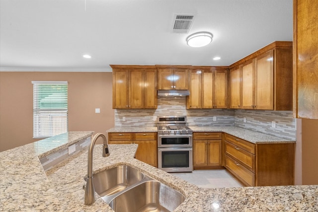 8423 Holiday Ln, Houston, TX 77075 - kitchen featuring double oven range, under cabinet range hood, a sink, brown cabinetry, and backsplash