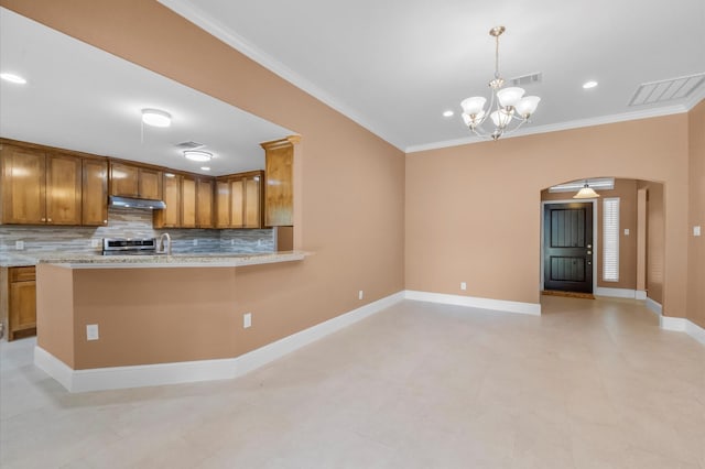 8423 Holiday Ln, Houston, TX 77075 - kitchen with arched walkways, under cabinet range hood, brown cabinetry, backsplash, and crown molding