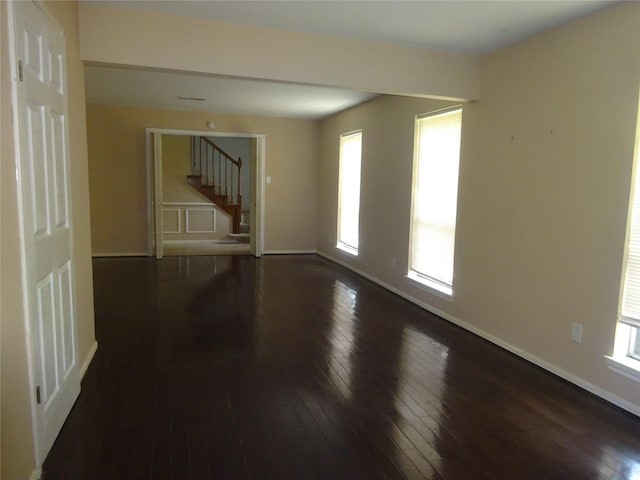 4810 Theall Rd, Houston, TX 77066 - unfurnished living room featuring dark wood-style flooring, healthy amount of natural light, and baseboards