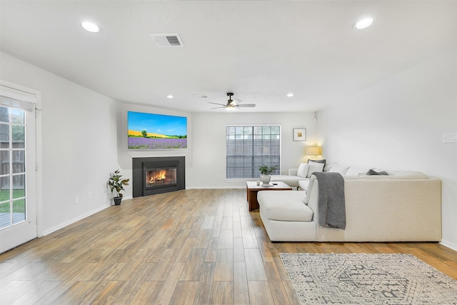16202 Elm Point Ct, Houston, TX 77095 - living area featuring a glass covered fireplace, a ceiling fan, recessed lighting, wood finished floors, and baseboards