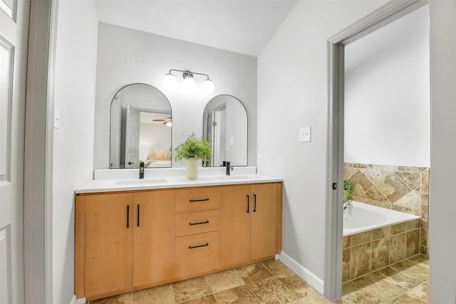 16202 Elm Point Ct, Houston, TX 77095 - full bath featuring double vanity, a bath, stone finish flooring, and baseboards