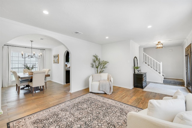 16202 Elm Point Ct, Houston, TX 77095 - living area with a chandelier, arched walkways, light wood-style floors, stairs, and recessed lighting