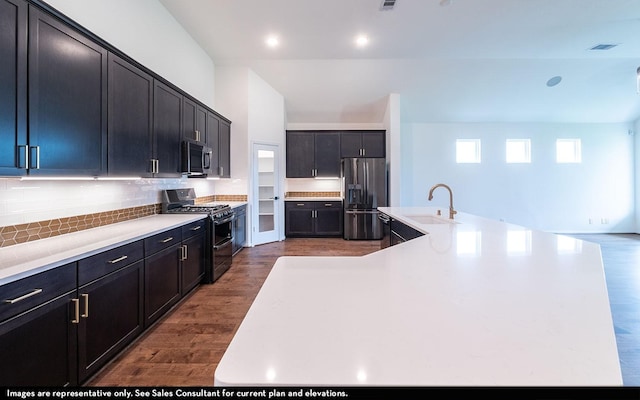 422 Riesling Dr, Alvin, TX 77511 - kitchen featuring stainless steel appliances, a sink, dark wood-type flooring, decorative backsplash, and a spacious island
