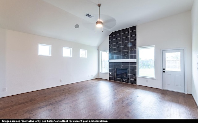 422 Riesling Dr, Alvin, TX 77511 - unfurnished living room with ceiling fan, wood finished floors, vaulted ceiling, and a tiled fireplace