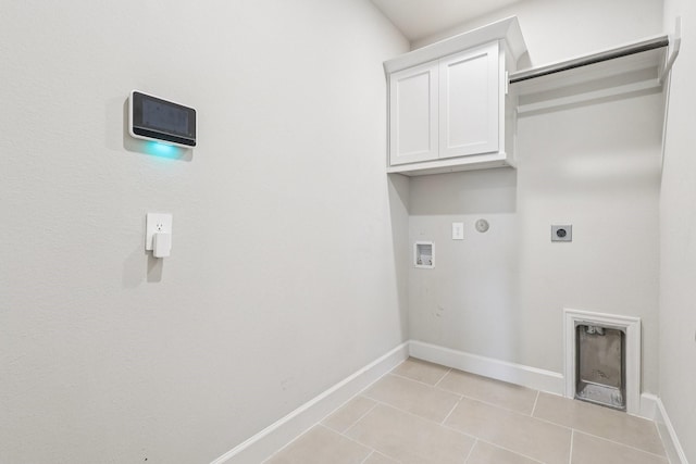 28814 Creekside Bend Dr, Fulshear, TX 77441 - laundry area with electric dryer hookup, gas dryer hookup, baseboards, light tile patterned floors, and cabinet space