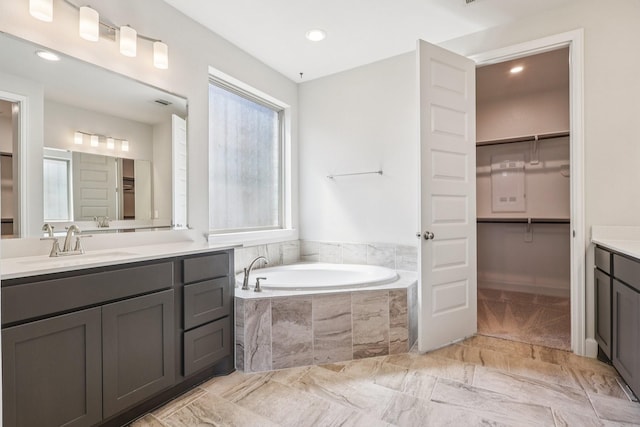 28814 Creekside Bend Dr, Fulshear, TX 77441 - bathroom featuring vanity, a garden tub, a walk in closet, marble finish flooring, and recessed lighting
