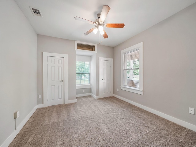 2402 49th St, Galveston, TX 77551 - unfurnished bedroom with multiple closets, carpet, baseboards, and ceiling fan