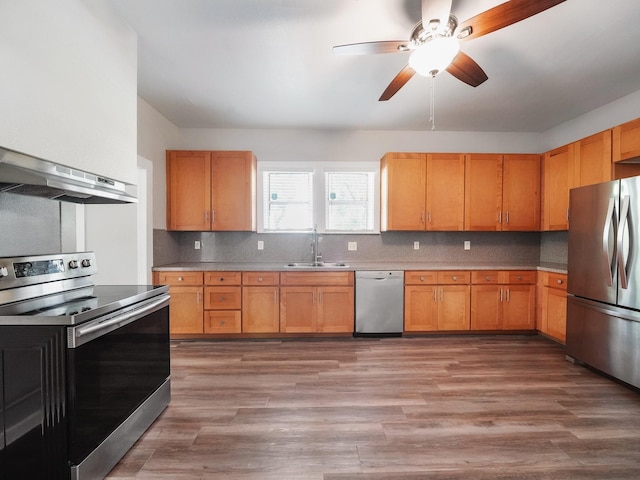 2402 49th St, Galveston, TX 77551 - kitchen with stainless steel appliances, a sink, extractor fan, a ceiling fan, and backsplash