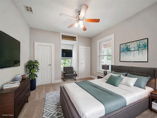 2402 49th St, Galveston, TX 77551 - bedroom featuring two closets, light carpet, baseboards, and a ceiling fan