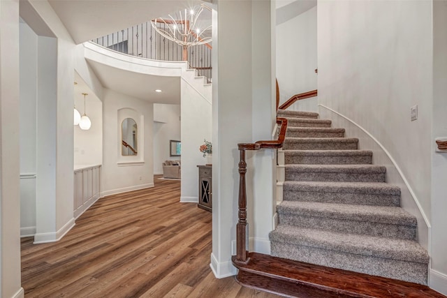 3806 W Benders Landing Blvd, Spring, TX 77386 - stairs with wood finished floors, a chandelier, a high ceiling, and baseboards