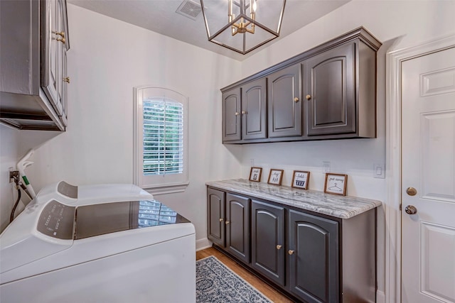 3806 W Benders Landing Blvd, Spring, TX 77386 - washroom with cabinet space, a chandelier, light wood-style floors, and independent washer and dryer