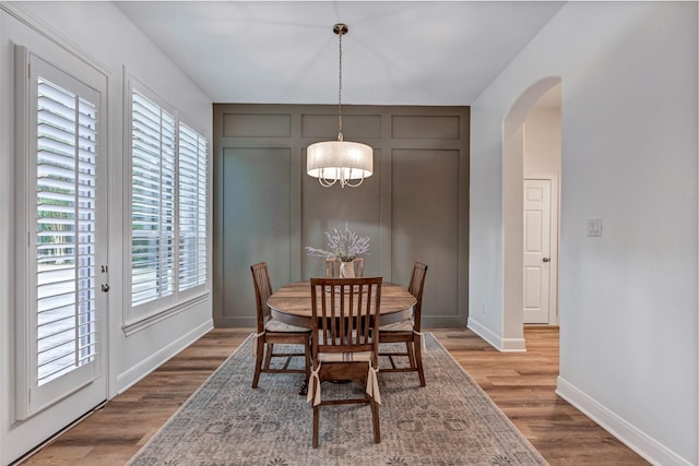 3806 W Benders Landing Blvd, Spring, TX 77386 - dining space with arched walkways, wood finished floors, baseboards, a chandelier, and a decorative wall