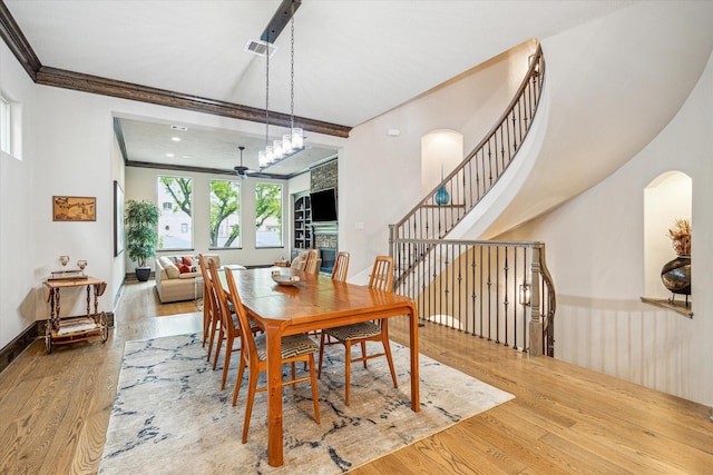 6619 Minola St, Houston, TX 77007 - dining room featuring arched walkways, wood finished floors, crown molding, ceiling fan, and baseboards