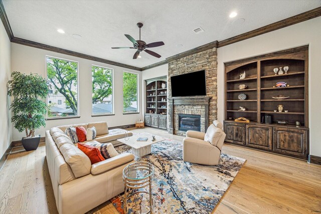 6619 Minola St, Houston, TX 77007 - living area featuring crown molding, a ceiling fan, a stone fireplace, light wood finished floors, and recessed lighting
