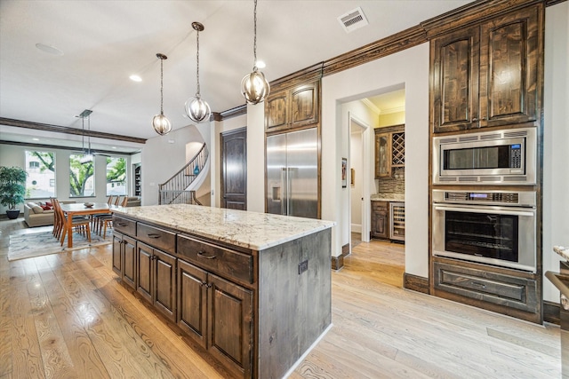 6619 Minola St, Houston, TX 77007 - kitchen featuring built in appliances, beverage cooler, ornamental molding, light wood-style flooring, and dark brown cabinets