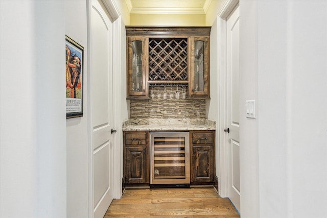 6619 Minola St, Houston, TX 77007 - indoor dry bar featuring beverage cooler, ornamental molding, light wood-style flooring, and tasteful backsplash