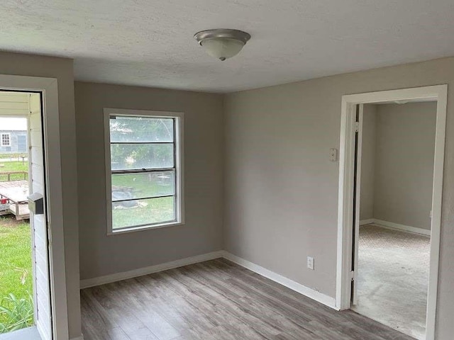 805 E Calhoun St, El Campo, TX 77437 - empty room with wood finished floors, baseboards, and a textured ceiling