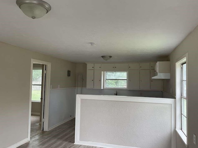 805 E Calhoun St, El Campo, TX 77437 - kitchen featuring light wood-style flooring, baseboards, and a peninsula