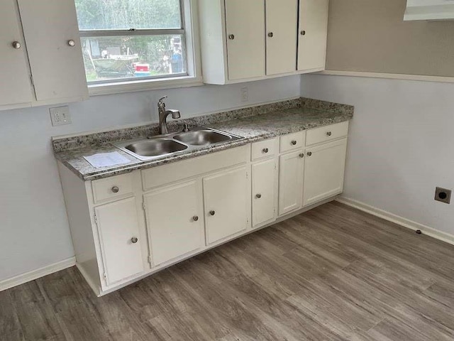 805 E Calhoun St, El Campo, TX 77437 - kitchen featuring a sink, wall chimney range hood, white cabinets, and wood finished floors