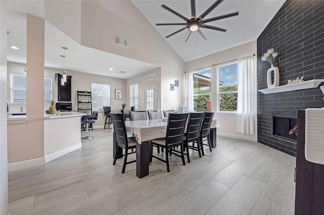9303 Filaree Ridge Ln, Houston, TX 77089 - dining space with a fireplace, a ceiling fan, plenty of natural light, baseboards, and vaulted ceiling