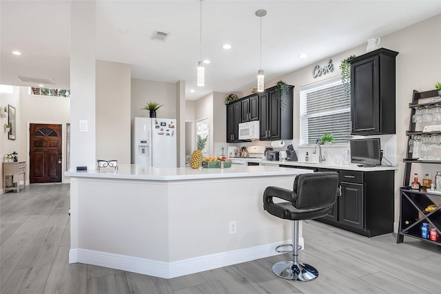 9303 Filaree Ridge Ln, Houston, TX 77089 - kitchen with white appliances, dark cabinets, light wood-style floors, light countertops, and recessed lighting