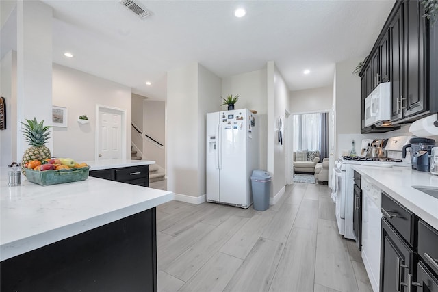9303 Filaree Ridge Ln, Houston, TX 77089 - kitchen featuring white appliances, dark cabinets, light countertops, baseboards, and recessed lighting
