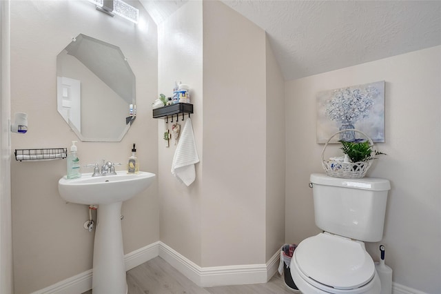 9303 Filaree Ridge Ln, Houston, TX 77089 - bathroom featuring toilet, baseboards, wood finished floors, vaulted ceiling, and a sink