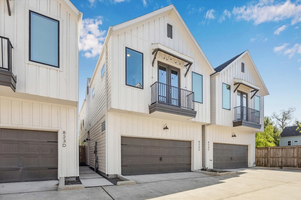 823 Mansfield St Unit E, Houston, TX 77091 - view of front of house with a balcony, an attached garage, and board and batten siding