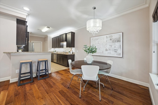 5250 Brinkman Ct, Houston, TX 77091 - dining area with ornamental molding, wood finished floors, a chandelier, and baseboards