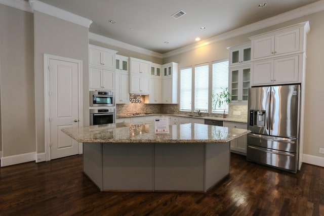 9642 Fannin Sta W, Houston, TX 77045 - kitchen featuring appliances with stainless steel finishes, a center island, dark wood finished floors, white cabinets, and baseboards