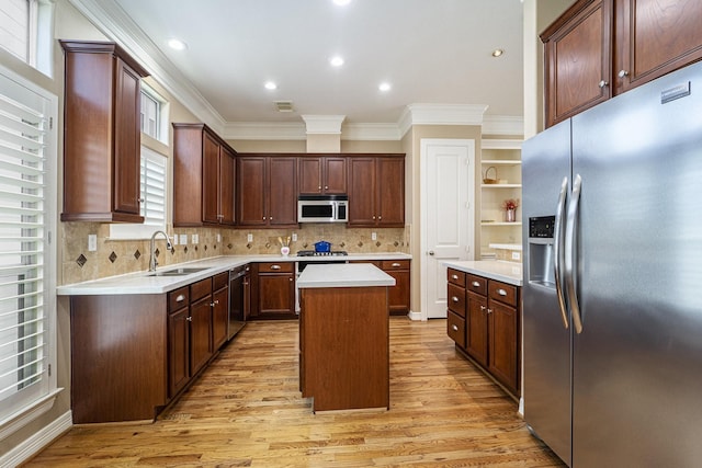 641 Hartman St, Houston, TX 77007 - kitchen featuring appliances with stainless steel finishes, a sink, crown molding, light wood-style flooring, and light countertops