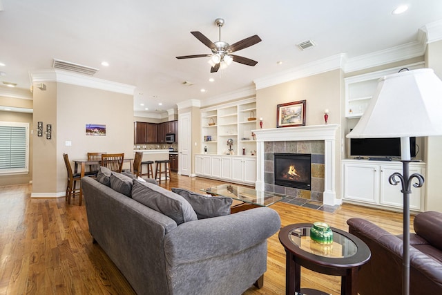 641 Hartman St, Houston, TX 77007 - living room featuring a ceiling fan, ornamental molding, wood finished floors, built in features, and recessed lighting