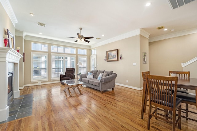 641 Hartman St, Houston, TX 77007 - living area with a ceiling fan, light wood-type flooring, a tile fireplace, baseboards, and crown molding