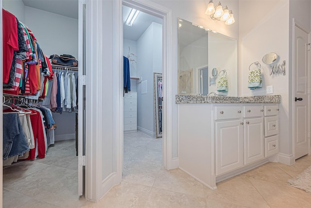 1622 Quail Ridge Dr, Katy, TX 77493 - full bathroom featuring vanity, a spacious closet, tile patterned flooring, and baseboards