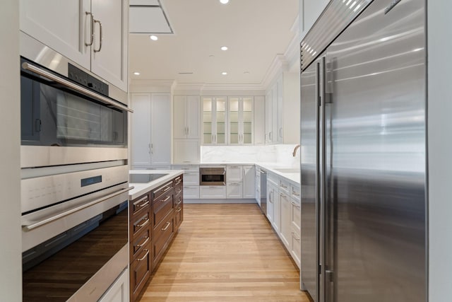 511 S Post Oak Ln Unit 2B, Houston, TX 77056 - kitchen with stainless steel appliances, white cabinetry, glass insert cabinets, light countertops, and recessed lighting
