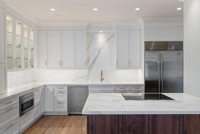 511 S Post Oak Ln Unit 2B, Houston, TX 77056 - kitchen featuring built in appliances, a sink, white cabinetry, glass insert cabinets, and crown molding