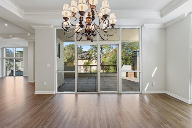 511 S Post Oak Ln Unit 2B, Houston, TX 77056 - unfurnished dining area featuring wood finished floors, a chandelier, baseboards, crown molding, and a raised ceiling