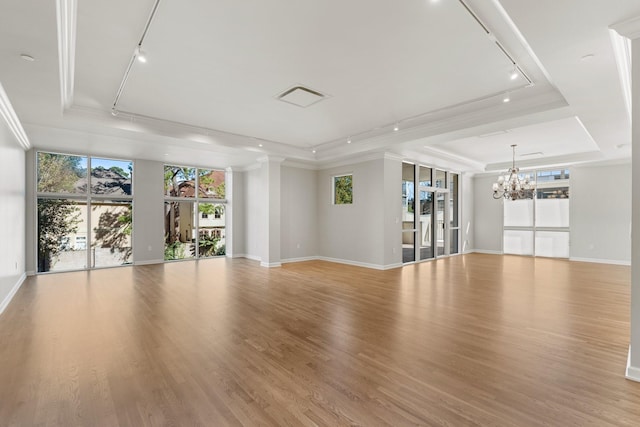 511 S Post Oak Ln Unit 2B, Houston, TX 77056 - unfurnished room with a tray ceiling, rail lighting, a chandelier, light wood-style flooring, and crown molding