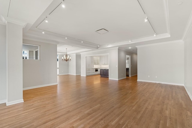 511 S Post Oak Ln Unit 2B, Houston, TX 77056 - unfurnished living room featuring rail lighting, a chandelier, ornamental molding, baseboards, and light wood-style flooring