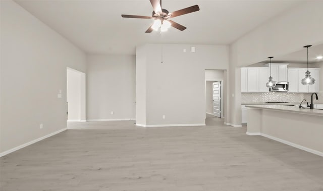 32407 Tallow Creek Dr, Waller, TX 77484 - unfurnished living room featuring ceiling fan, light wood finished floors, and baseboards