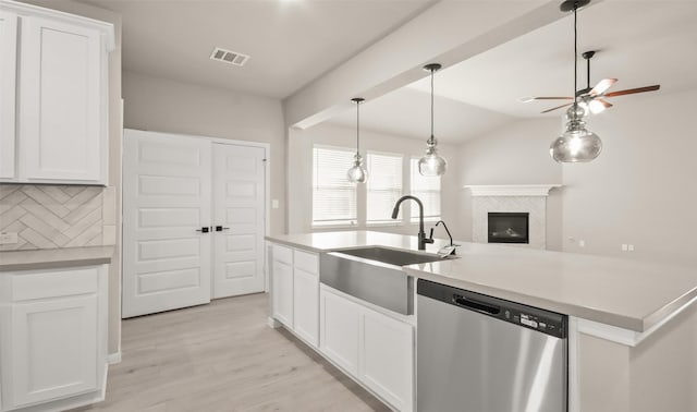 32407 Tallow Creek Dr, Waller, TX 77484 - kitchen with stainless steel dishwasher, a sink, decorative backsplash, a ceiling fan, and light wood-style flooring