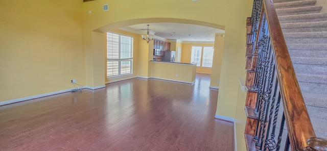 10722 Clearview Villa Pl, Houston, TX 77025 - unfurnished living room with wood finished floors, arched walkways, crown molding, stairs, and a chandelier