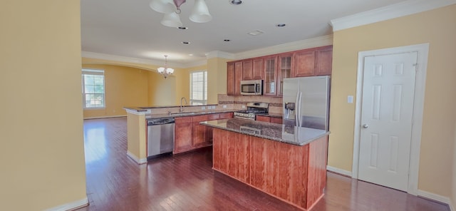 10722 Clearview Villa Pl, Houston, TX 77025 - kitchen with stainless steel appliances, a chandelier, a peninsula, dark wood-style flooring, and glass insert cabinets