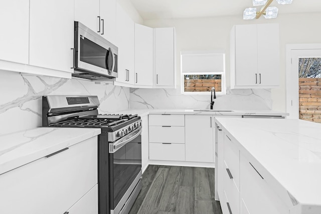 3632 Dreyfus St, Houston, TX 77021 - kitchen featuring stainless steel appliances, white cabinetry, light stone countertops, backsplash, and dark wood-type flooring