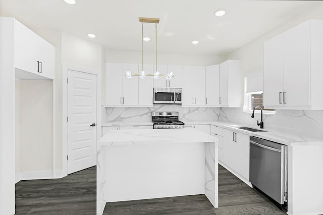 3632 Dreyfus St, Houston, TX 77021 - kitchen with appliances with stainless steel finishes, a kitchen island, recessed lighting, white cabinets, and decorative backsplash
