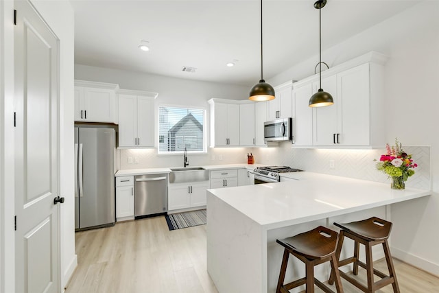 1503 Chestnut St Unit B, Houston, TX 77009 - kitchen featuring stainless steel appliances, a peninsula, light wood-type flooring, backsplash, and recessed lighting
