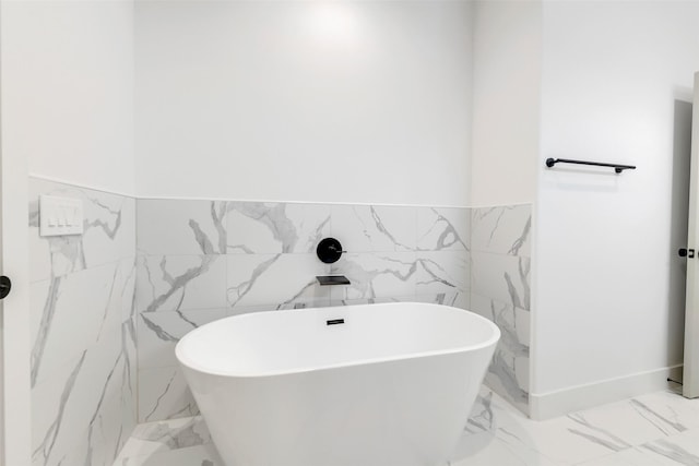1503 Chestnut St Unit B, Houston, TX 77009 - bathroom featuring marble tiled flooring, a freestanding bath, tile walls, and wainscoting
