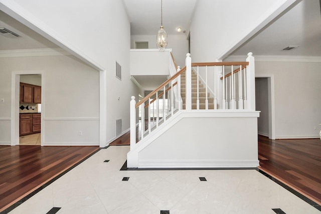 4311 Roaring Rapids Dr, Pasadena, TX 77059 - stairway featuring crown molding, baseboards, tile patterned flooring, and a high ceiling