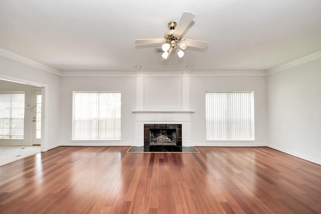 4311 Roaring Rapids Dr, Pasadena, TX 77059 - unfurnished living room featuring a ceiling fan, wood finished floors, a tile fireplace, crown molding, and baseboards